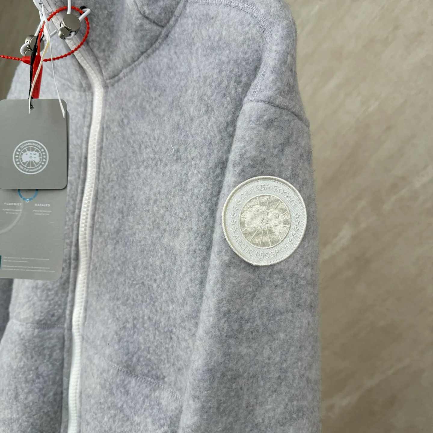 P810 Canada Goos Fleece Badge Hooded Jacket SIZE S/M/L/XL The fabric is made of wool as the main body, with a very small amount of spandex and polyester fiber blended into the wool fleece fabric. The sleeves and hem are closed with 2×2 ribbing. Its strong elasticity can closely fit wrists and waists of different thicknesses, forming an effective 'seal' to prevent cold wind from blowing back. It can still maintain its original shape after repeated stretching and use, and is not easy to loose and deform. And the ribbed cuffs can convey a sense of design and enhance the visual beauty.